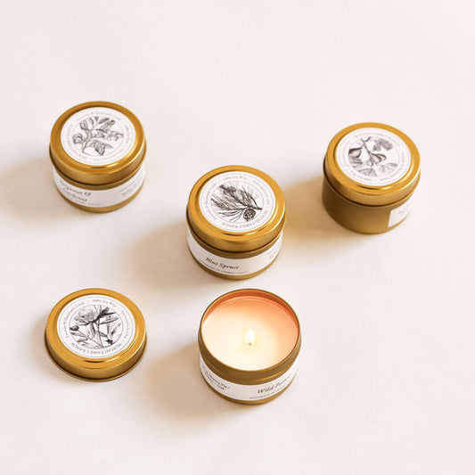 Unlit farmhouse tin candles with gold lids, cream labels (various scents)