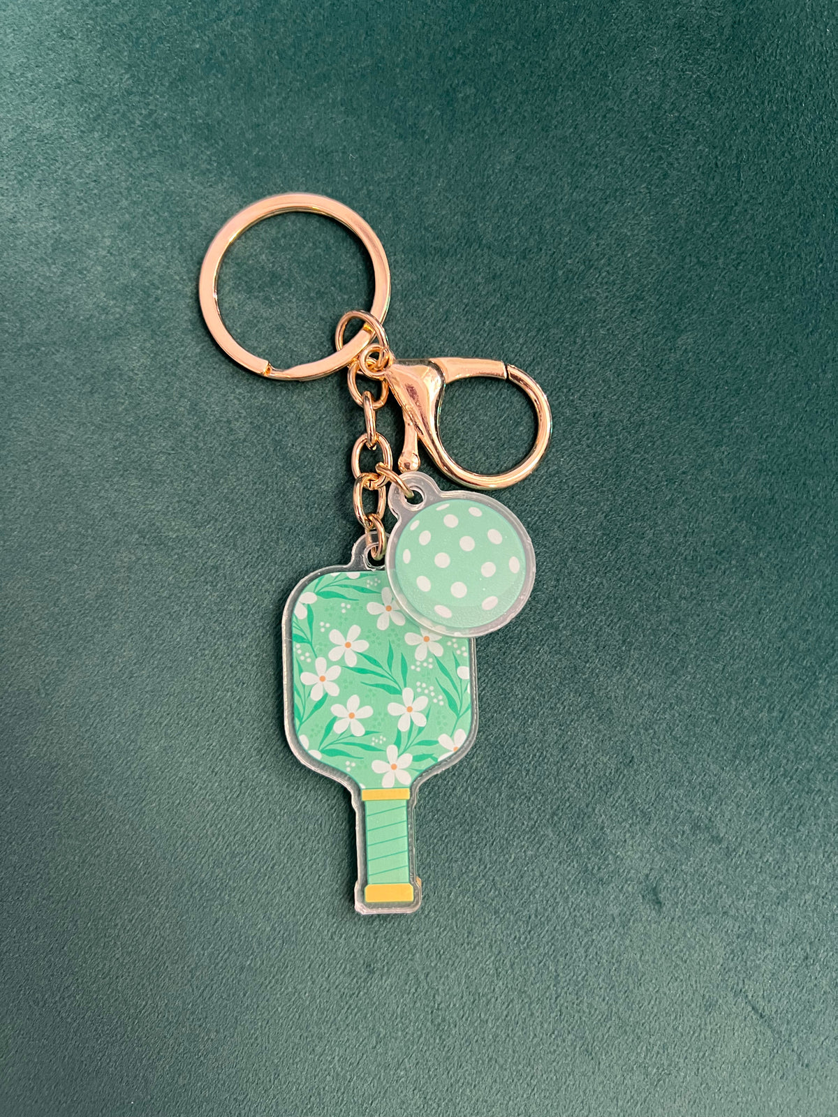 Acrylic pickleball paddle keychain with a mint floral paddle and pale green ball charm