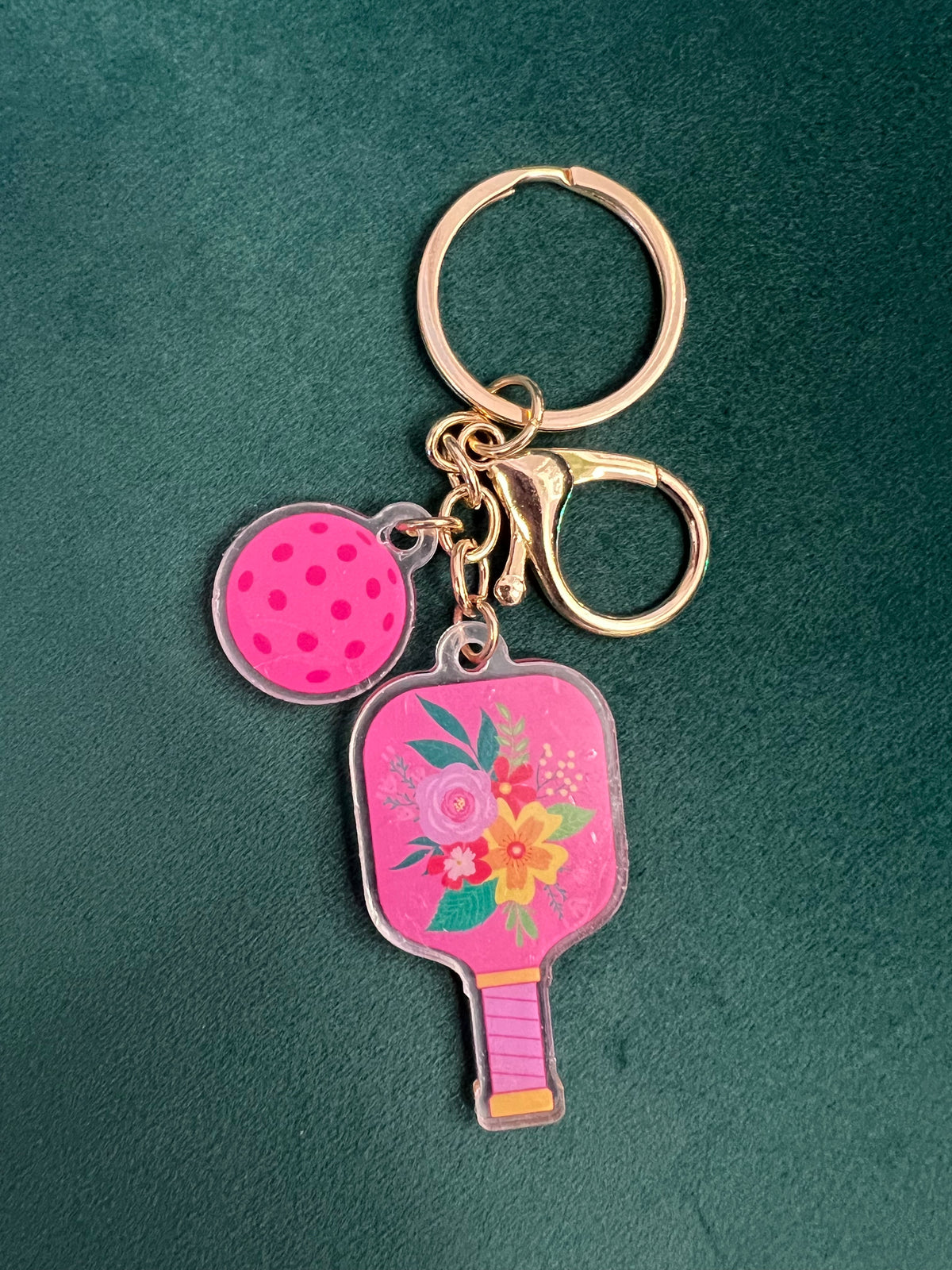 Acrylic pickleball paddle keychain with pink floral paddle and matching perforated ball charm