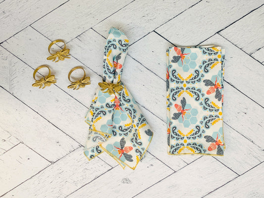 Bee and honeycomb print cloth napkin set of four, light blue with gray and orange accents