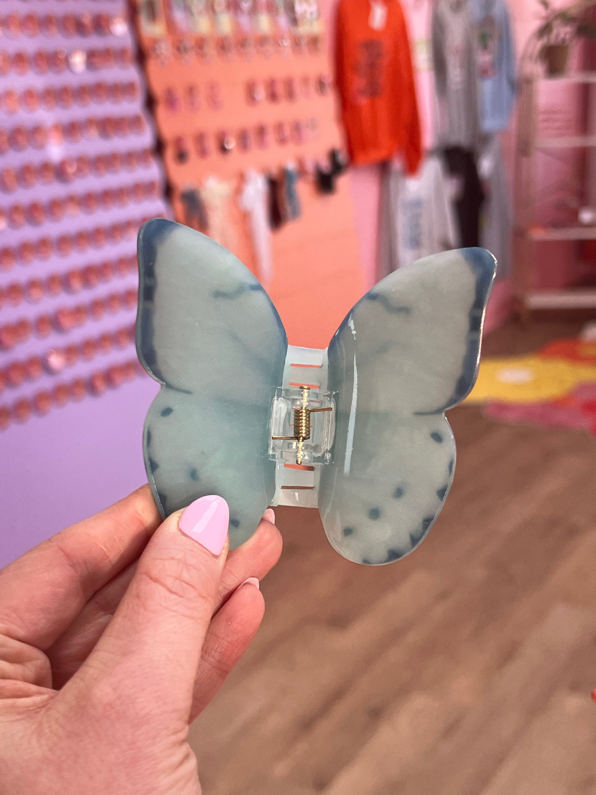 Oopsy Daisy hair claw, light blue butterfly shape with speckled details.