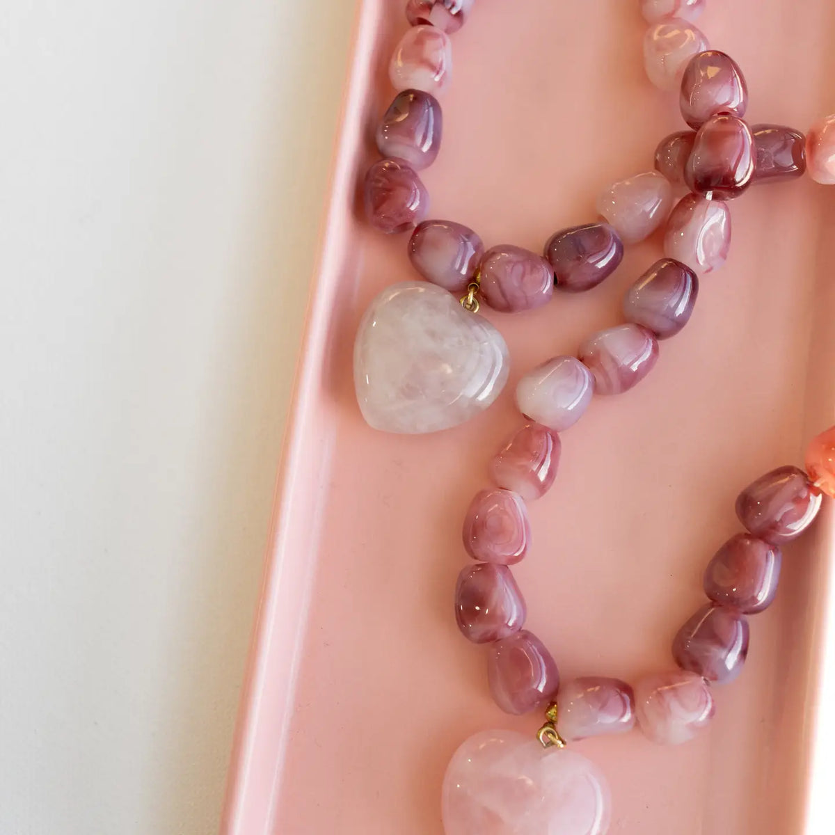 Pink and mauve bead necklace with a pale heart-shaped pendant