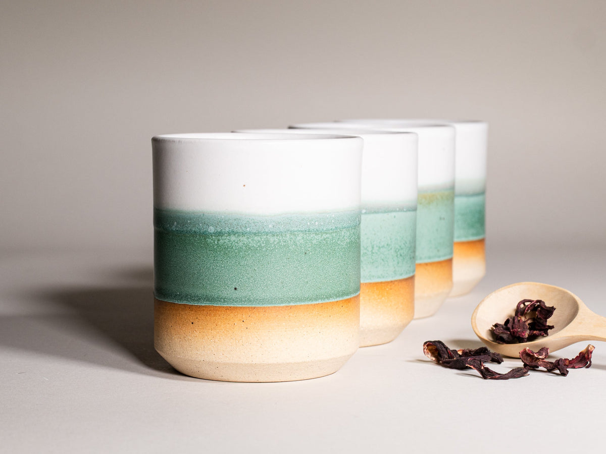 Green and white stoneware smoothie cups, 14 oz, set of cups in a row.