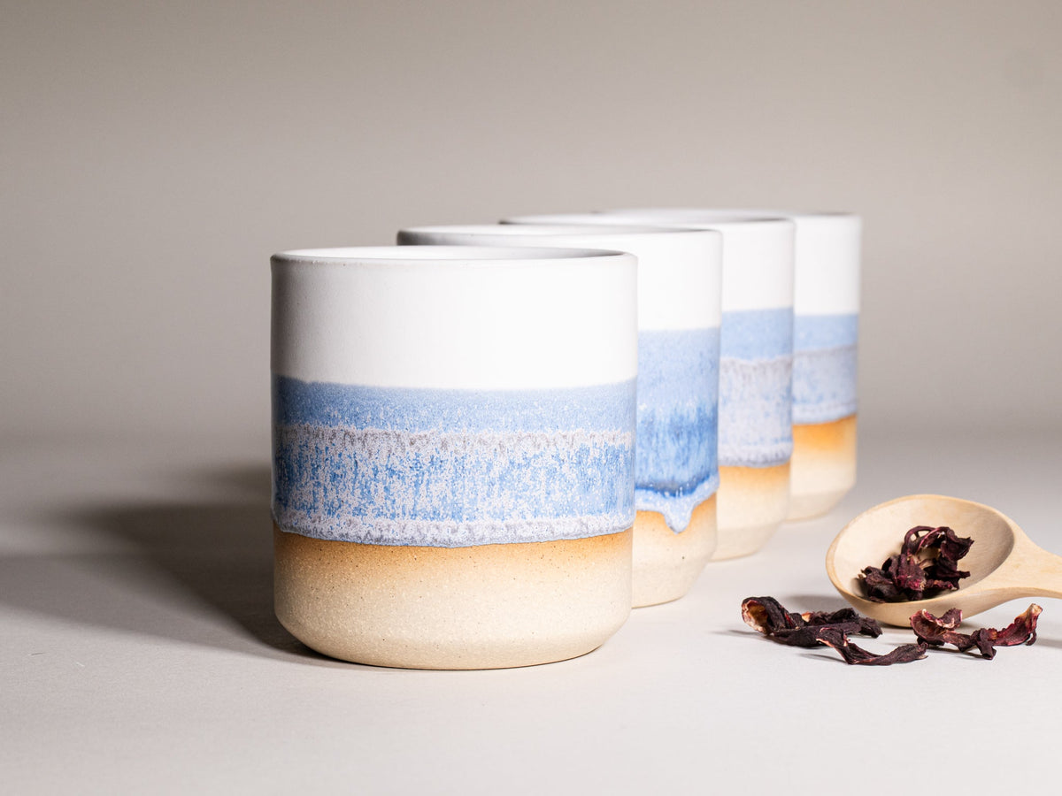 Set of stoneware smoothie cups with blue band and tan bases, speckled glaze