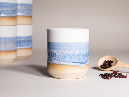 14 oz stoneware smoothie cup with blue and white band, speckled glaze, and tan base