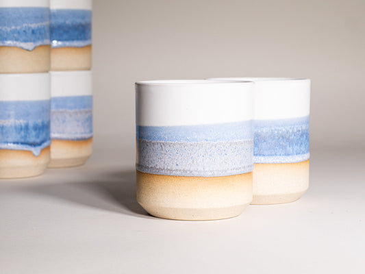 Stoneware smoothie cup with blue horizontal band and tan bottom, speckled glaze