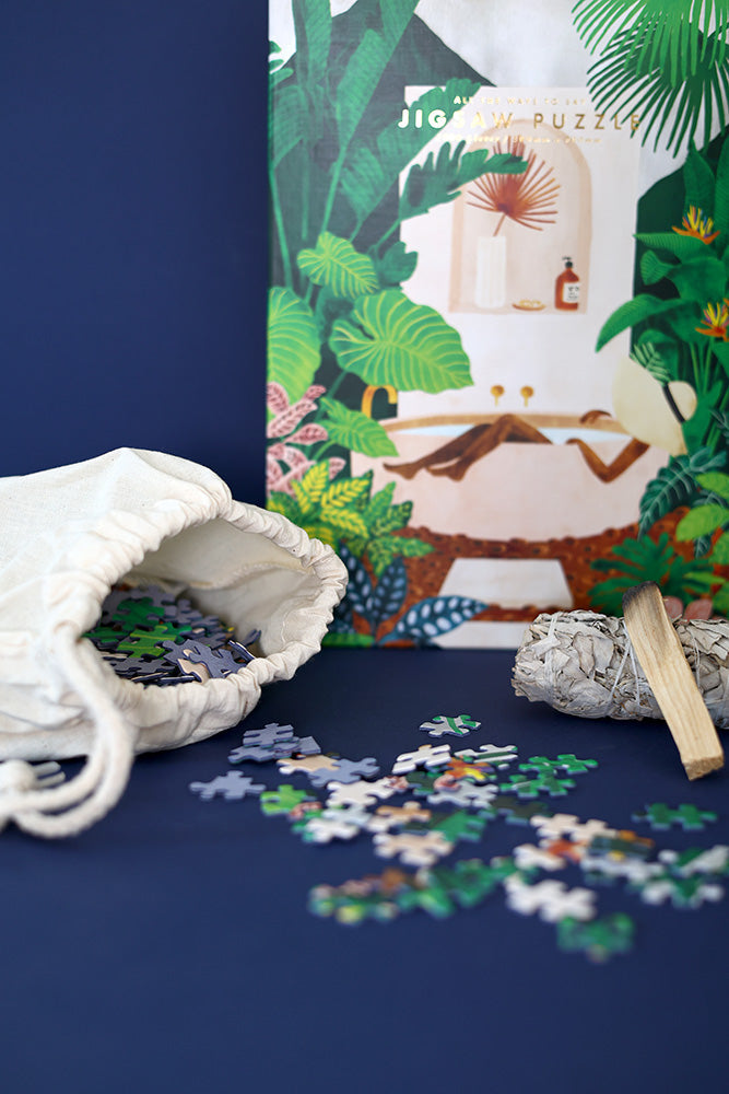 Jigsaw puzzle pieces near an open fabric bag with the puzzle box visible