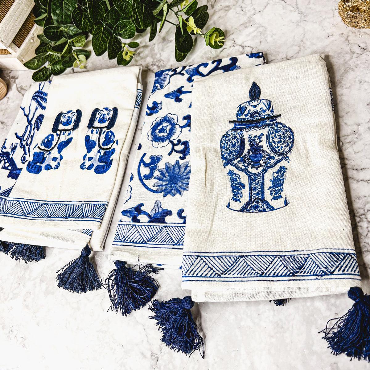 Cream and blue chinoiserie tea towels with urn, floral, and dog designs, navy tassels