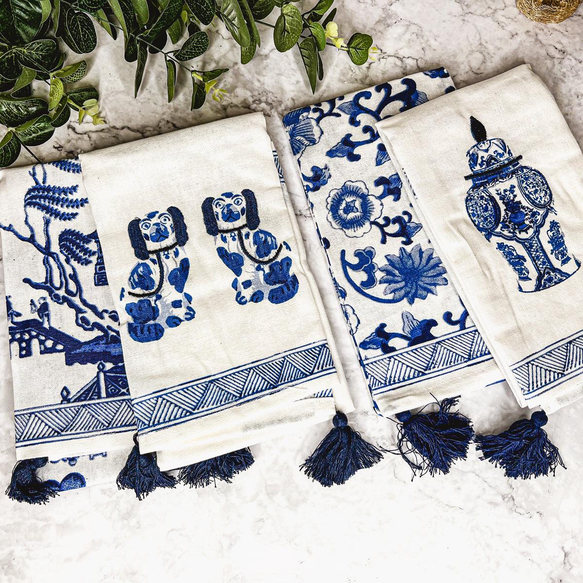 Cream and blue chinoiserie tea towels with scenic motifs, navy tassel fringe