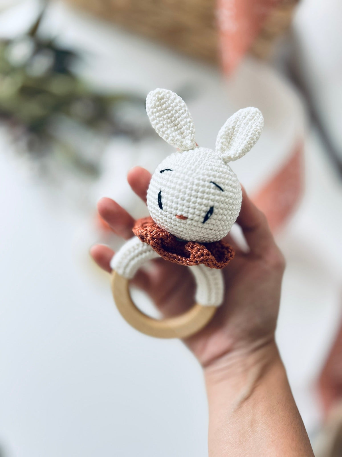 Bunny rattle teether with crocheted white bunny, orange scarf, and wooden ring handle