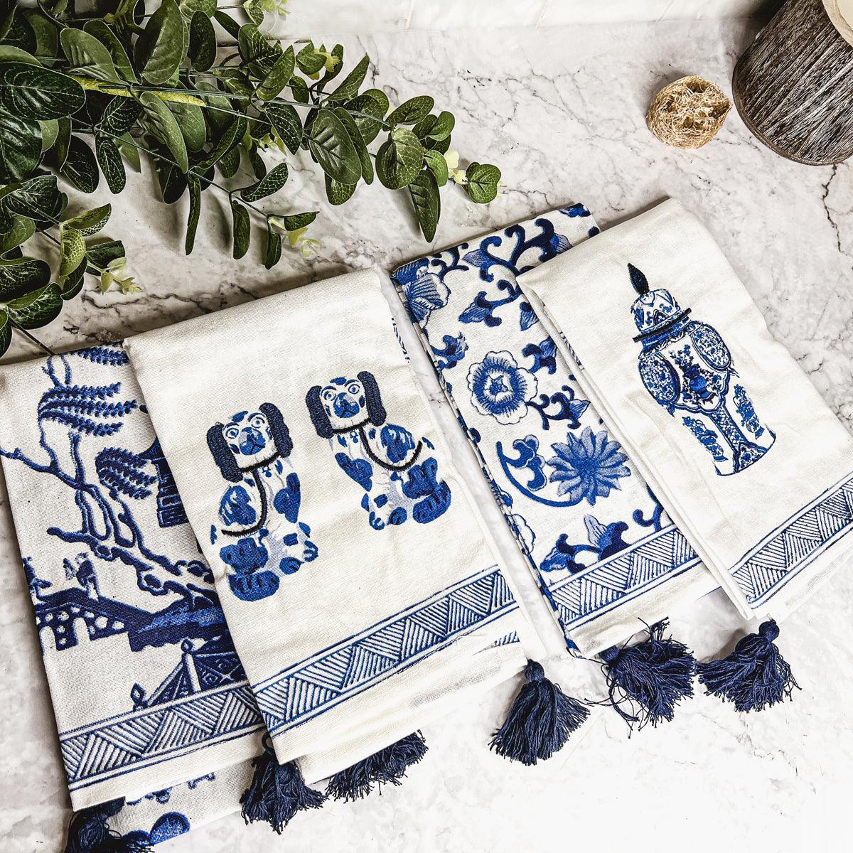 Cream and blue chinoiserie tea towels with dog and vase prints, navy tassel fringe
