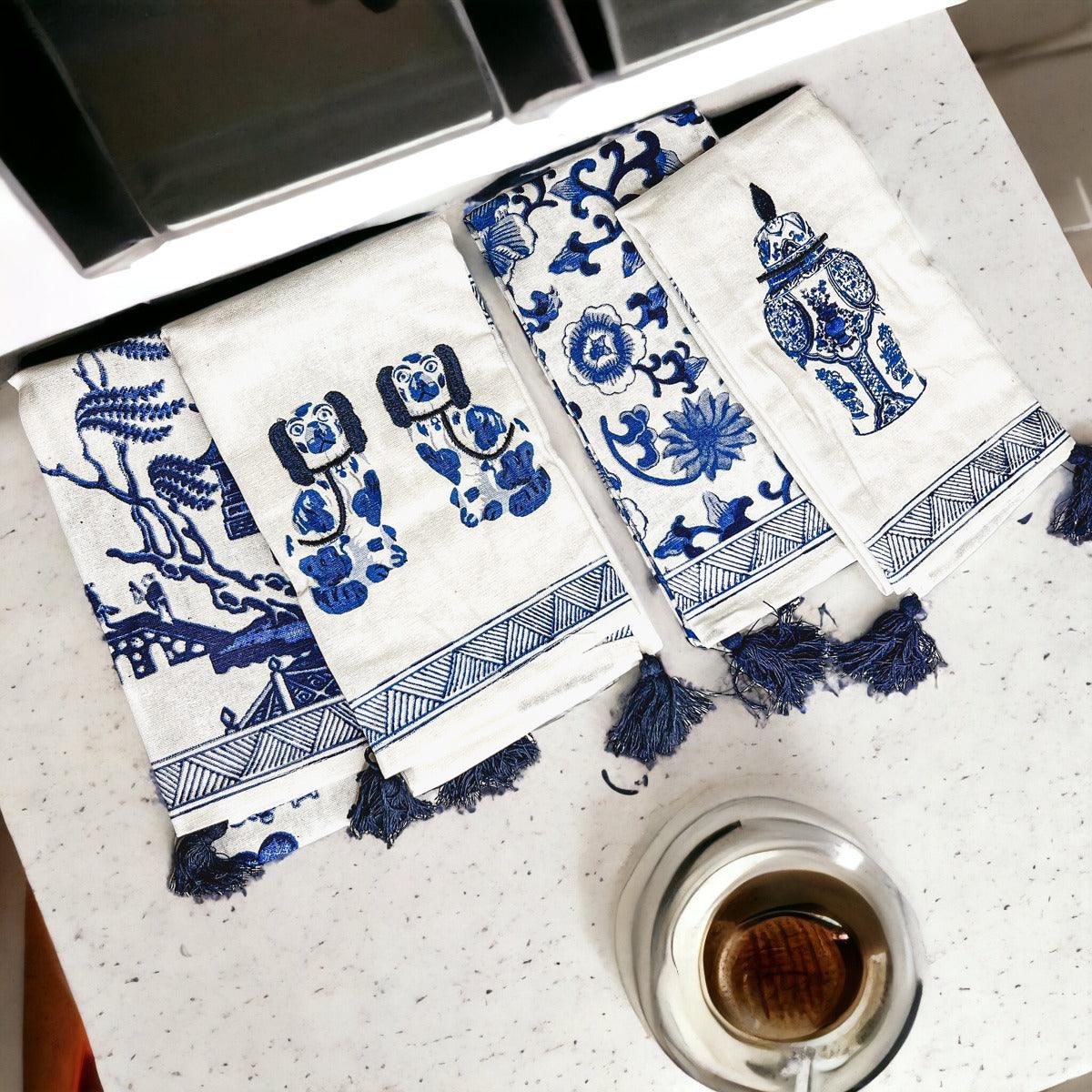 Chinoiserie tea towels set with blue motifs and tassel fringe beside a cup