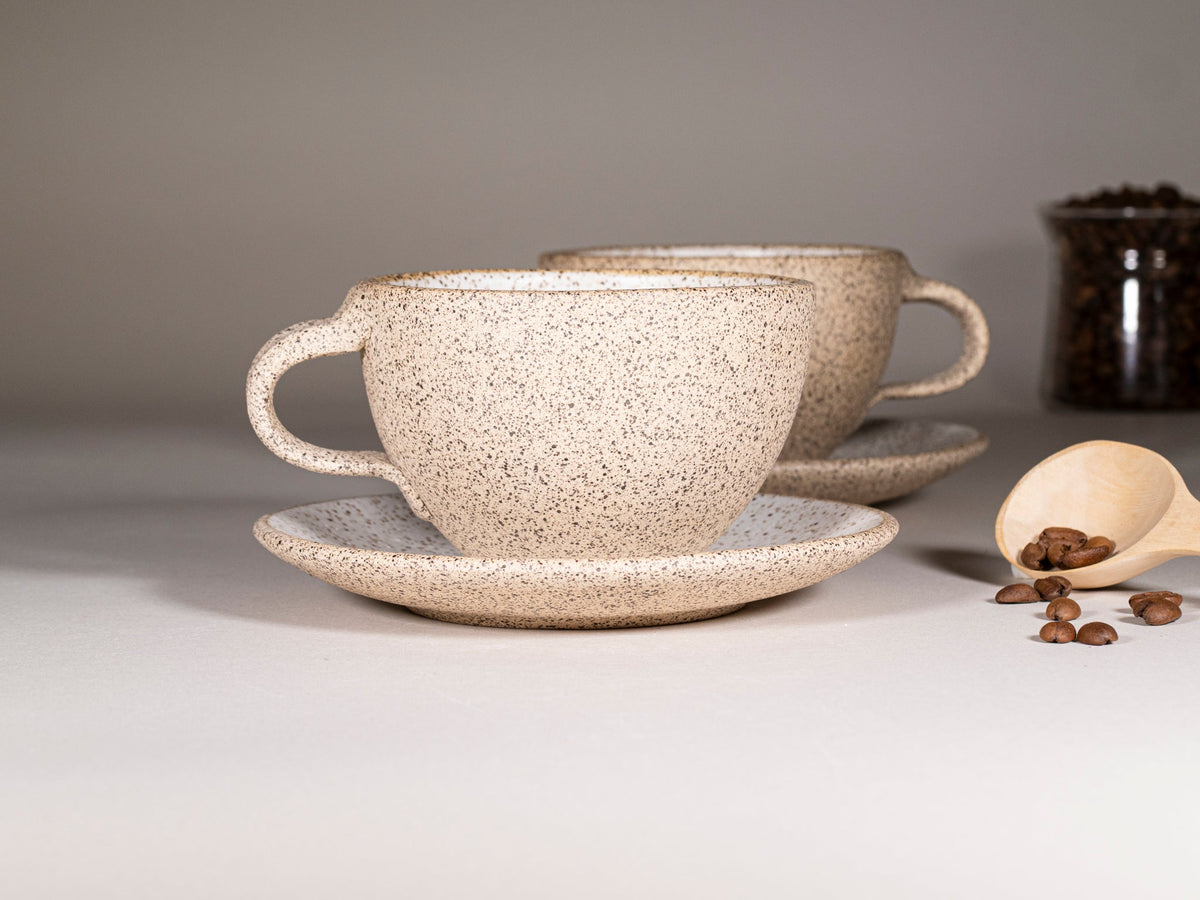 Speckled stoneware cappuccino cup with handle and saucer, curved profile