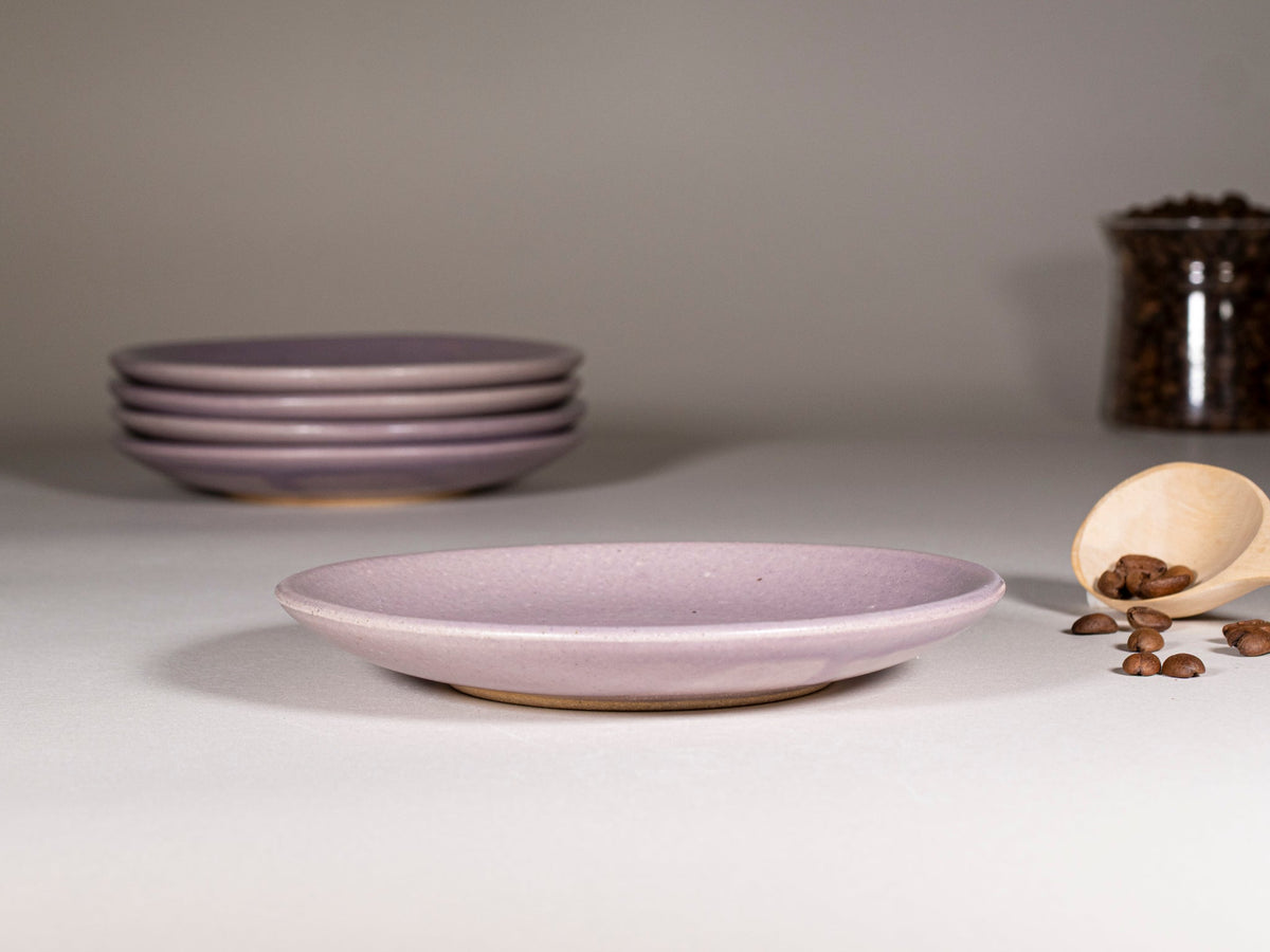 Purple stoneware saucer, shallow plate with a stack of matching saucers.