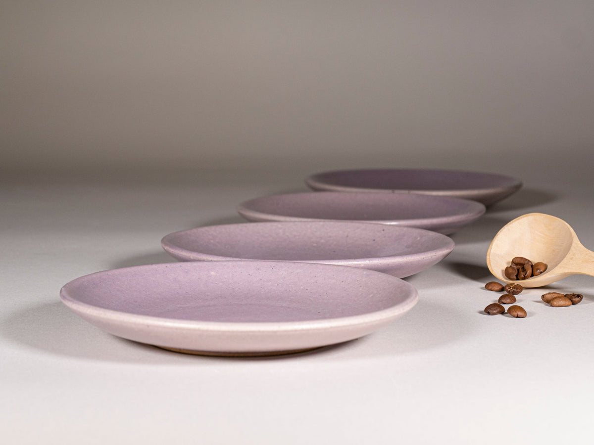 Purple stoneware saucer set, stack of plates with speckled finish.