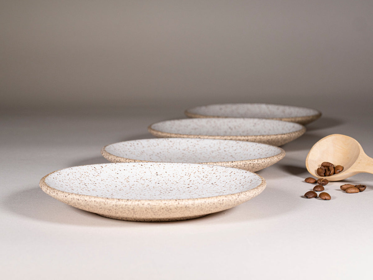 Speckled stoneware saucer set, stacked round plates in speckled white