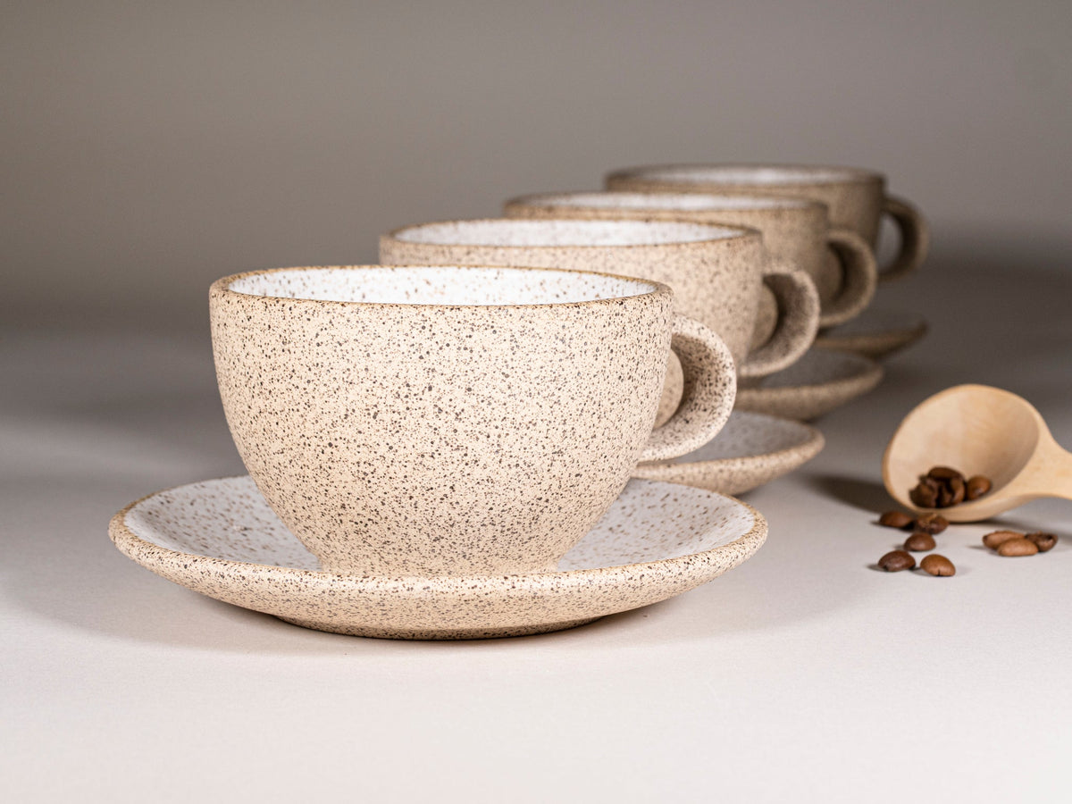 Speckled stoneware latte cup with handle and matching saucer, white with speckles