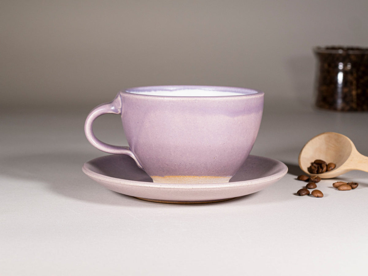 Purple stoneware cup with handle and saucer, glossy glaze with cream-toned base