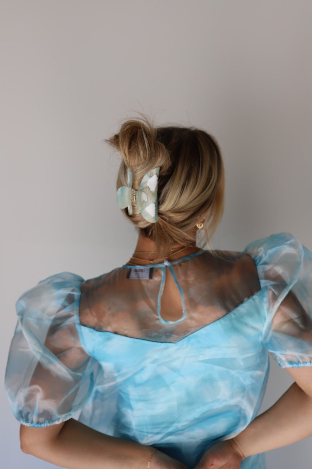 Blue translucent floral hair claw clip, styled on a blonde low bun