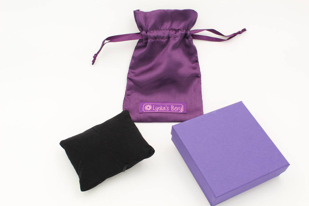 Jewelry gift set with a purple drawstring pouch, black pouch and purple box