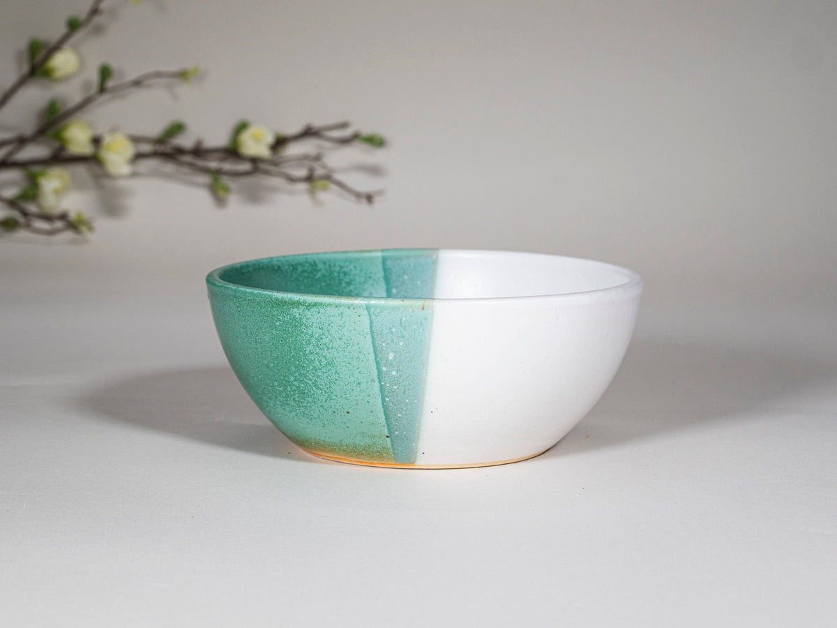 Green and white stoneware soup bowl, front three-quarter view