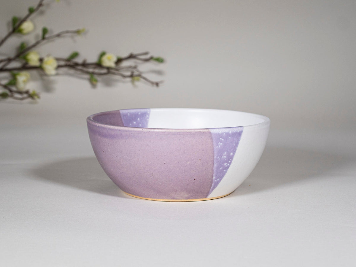 Purple and white stoneware soup bowl with speckled inlay, side view