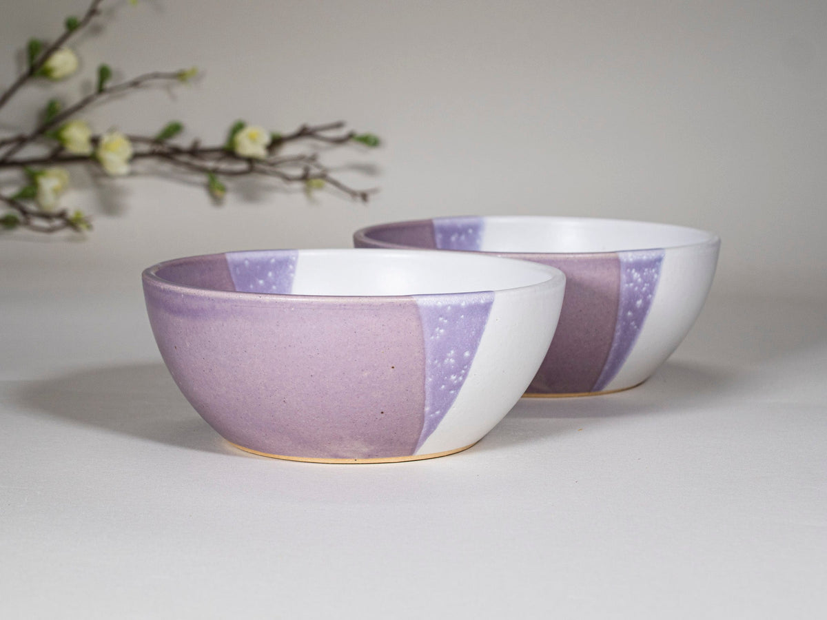 Set of purple and white stoneware soup bowls stacked, speckled design