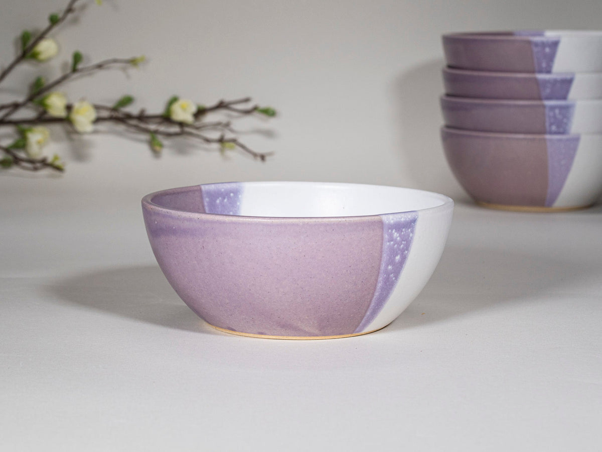 Purple and white stoneware soup bowl with speckled inlay, angled view