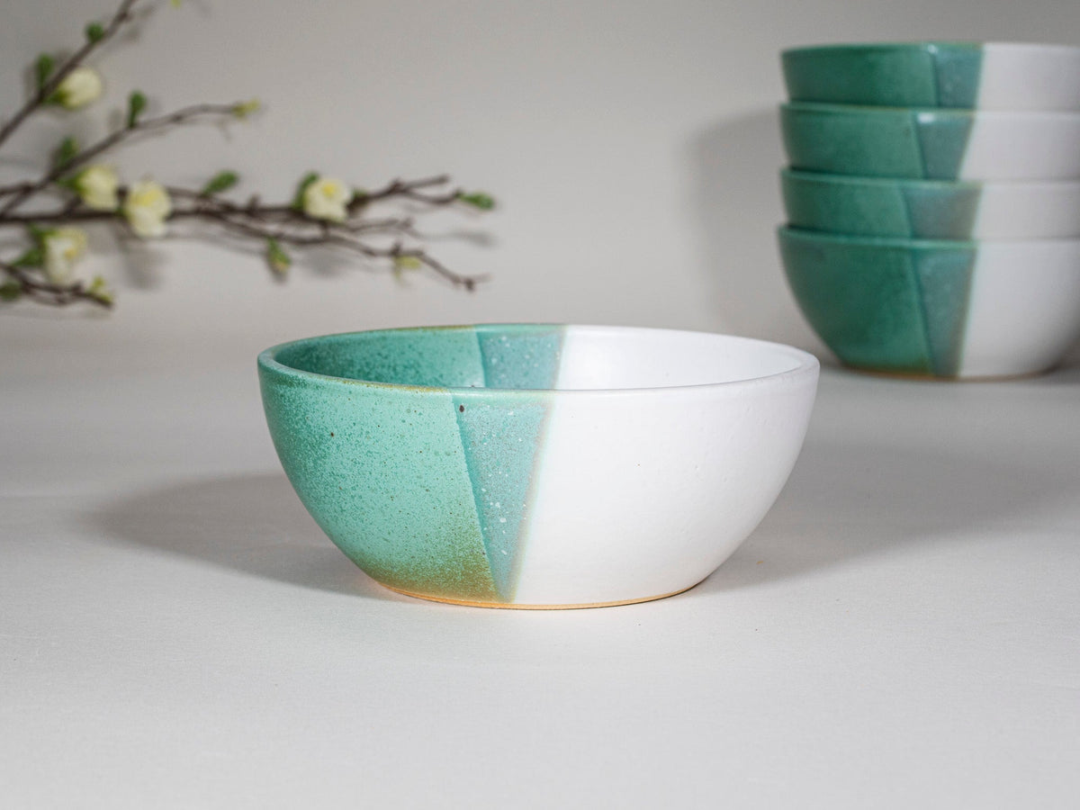 Stacked green and white stoneware soup bowls with speckled glaze