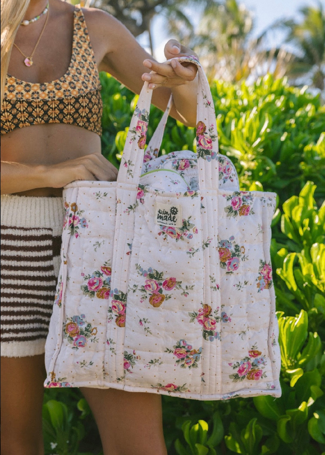Floral zip tote bag held by model, rose print with zip top