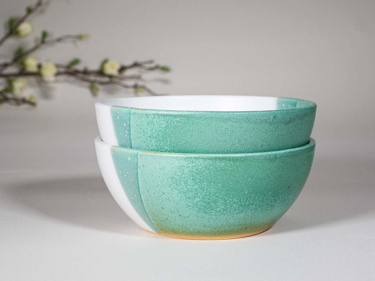 Two stacked green and white stoneware soup bowls, angled view