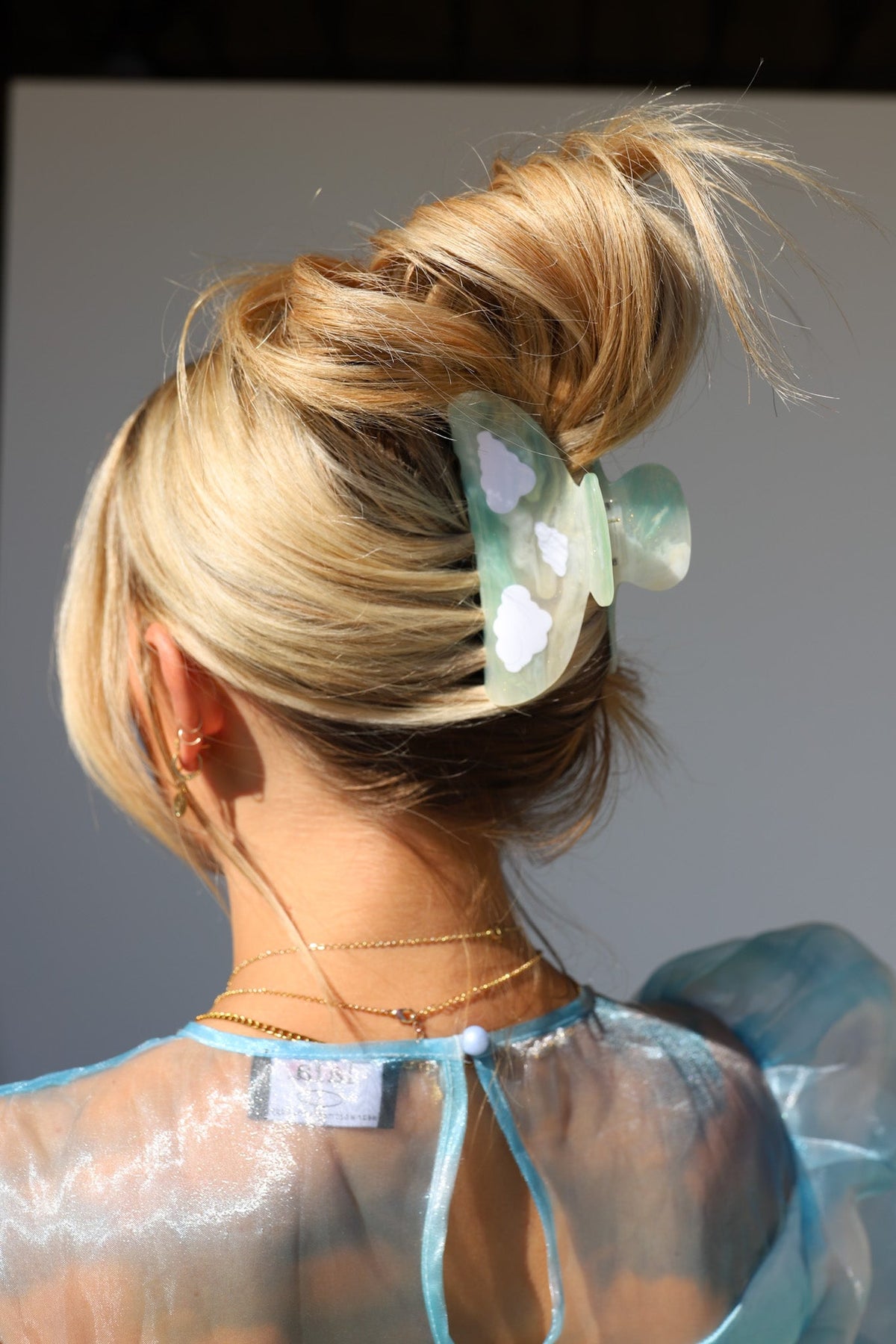 Translucent green-and-clear floral hair claw clip with white flower accents