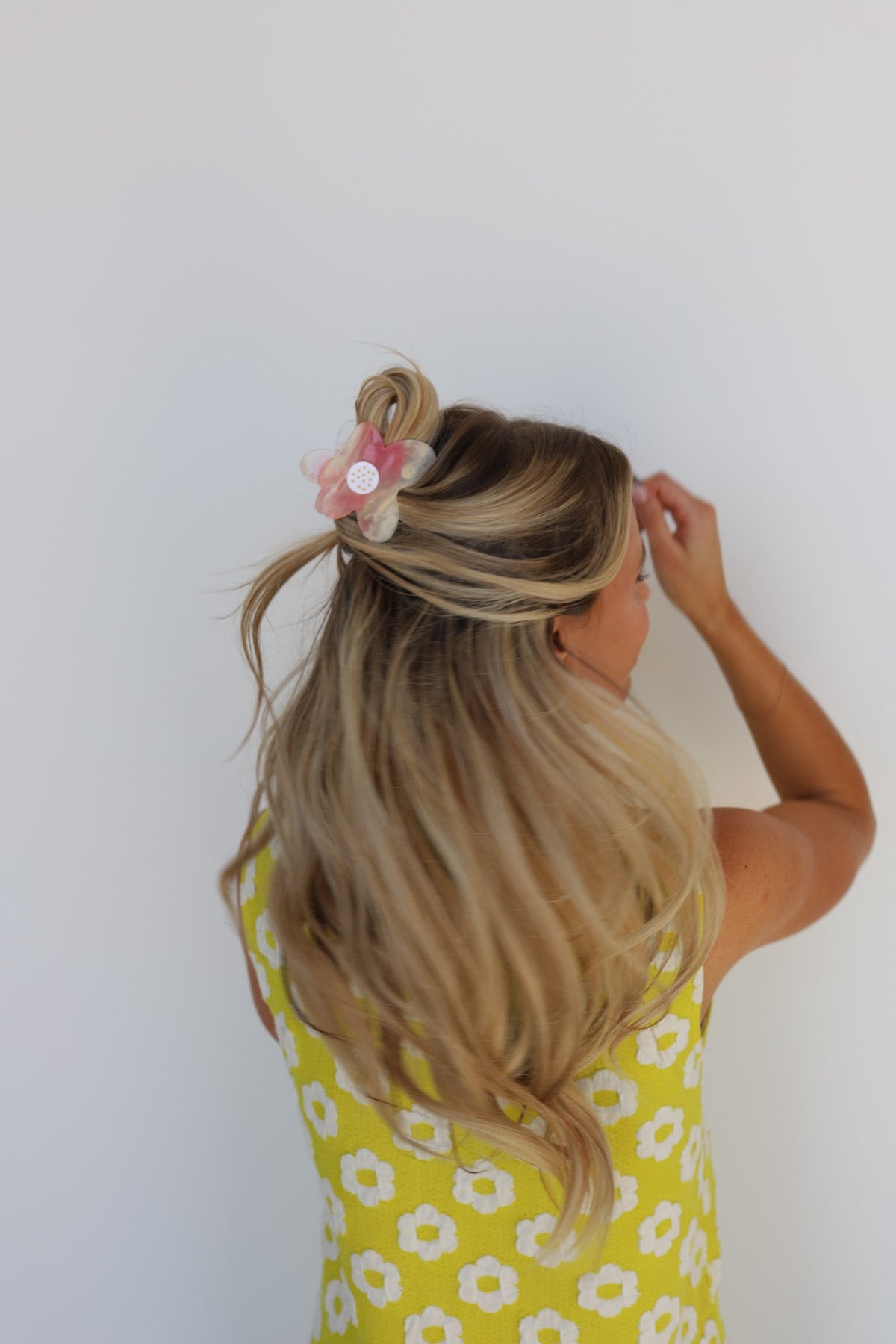 Floral hair claw clip on long blonde hair with pink flower; yellow floral top