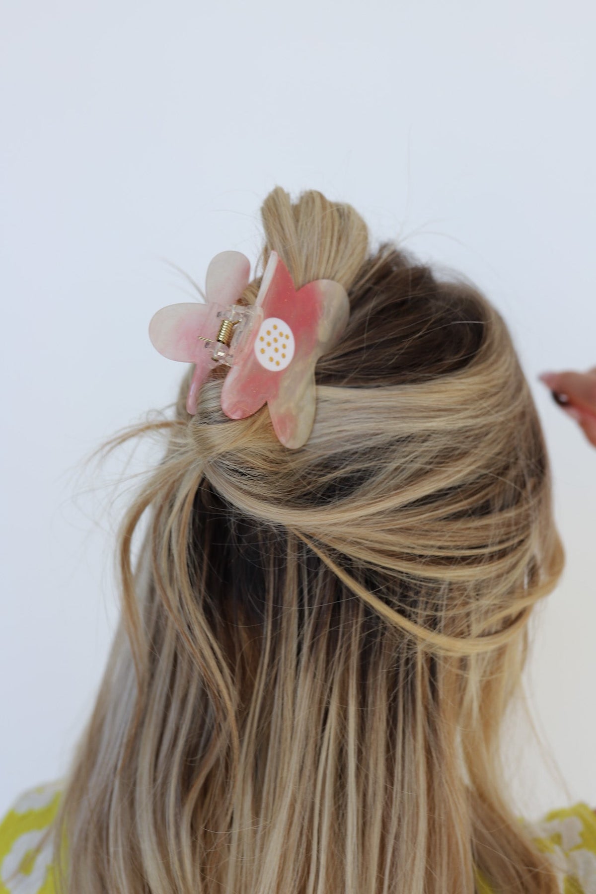Floral hair claw clip with pink-and-cream petals on blonde hair bun