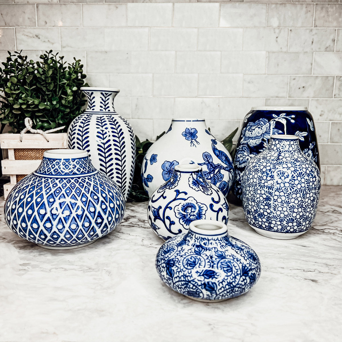 Blue-and-white ceramic vases grouped on a marble floor, mixed silhouettes
