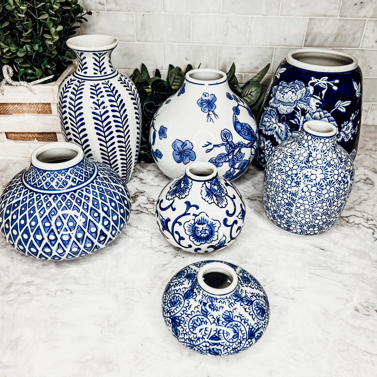 Blue-and-white ceramic vases arranged on a marble surface, assorted shapes