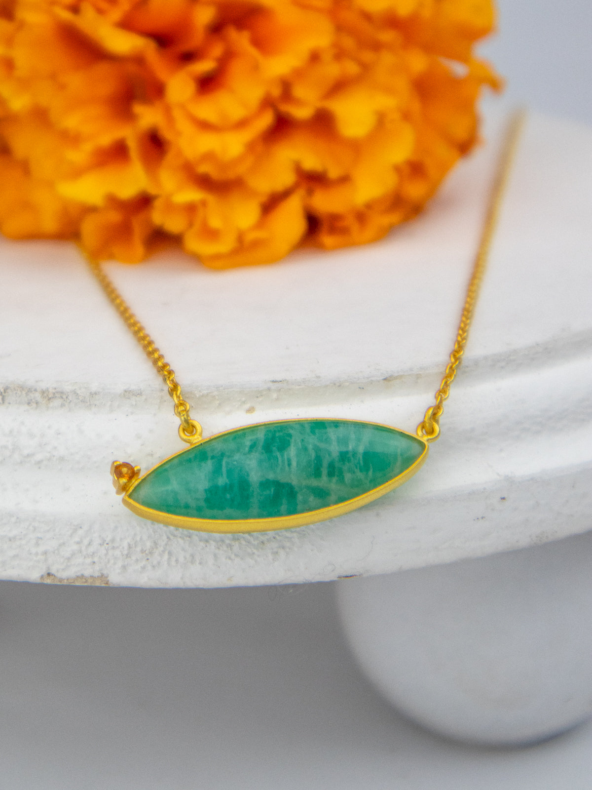 Gold chain necklace with oval blue-green stone pendant