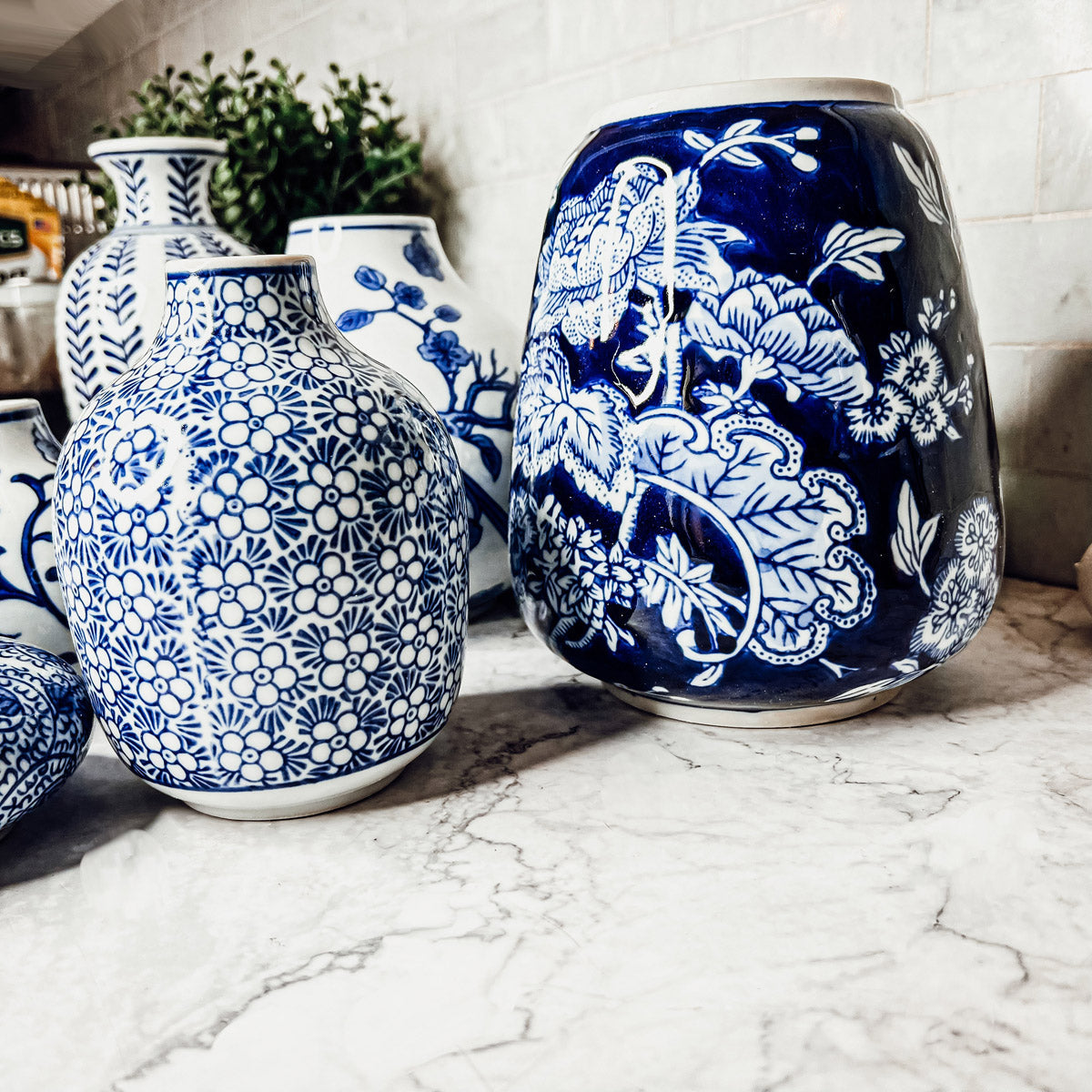 Blue-and-white ceramic vase with embossed floral medallion pattern, rounded body