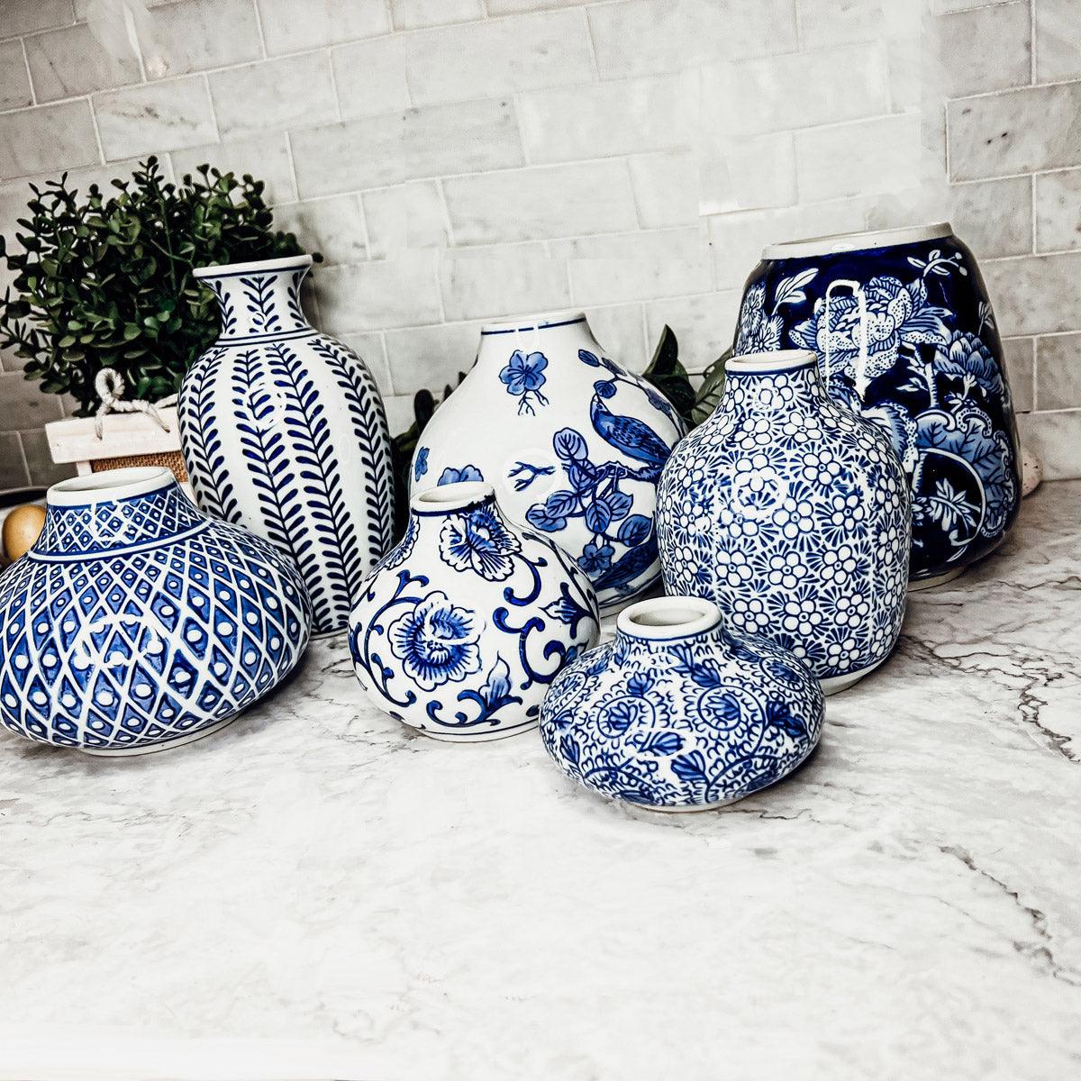 Blue-and-white ceramic vases on a marble surface, including rounded and narrow neck