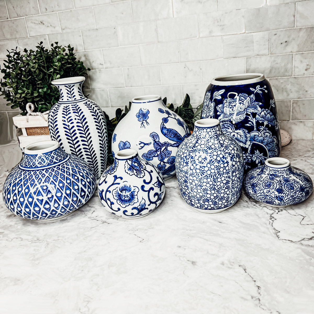 Blue-and-white ceramic vases on a countertop, mixed round and tall forms
