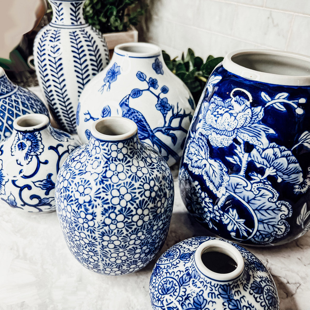 Close-up of blue and white ceramic vases with bold floral and animal motifs