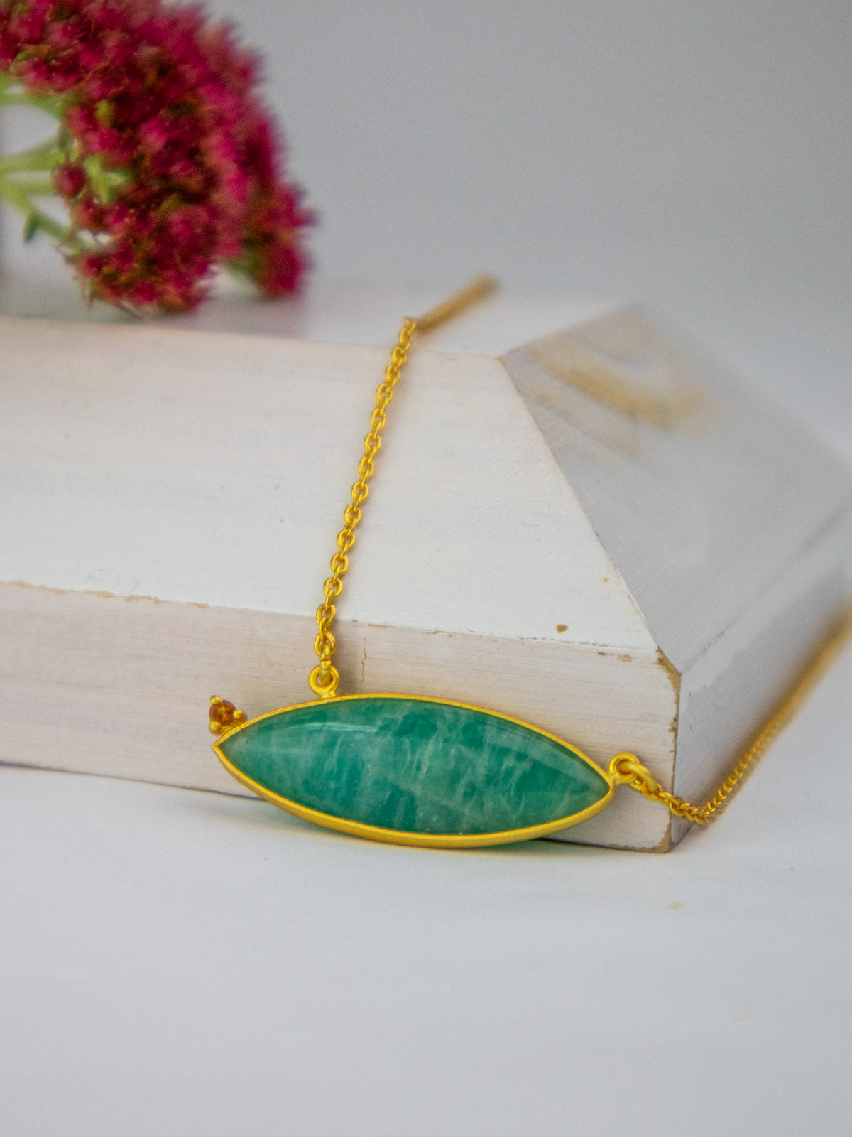 Gold chain necklace with large oval blue-green stone pendant