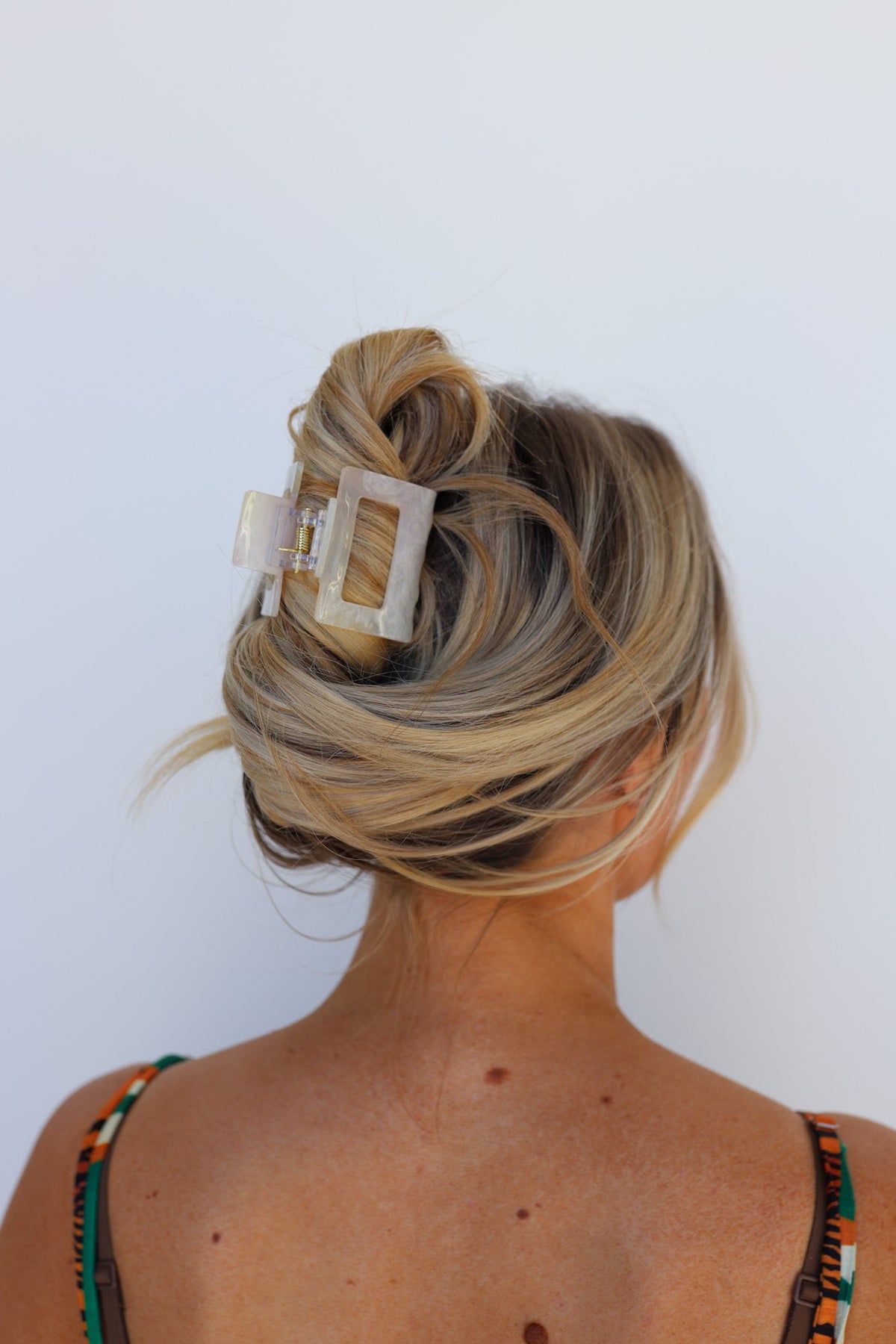 Color-changing hair claw with translucent gold-beige and clear panel tiles