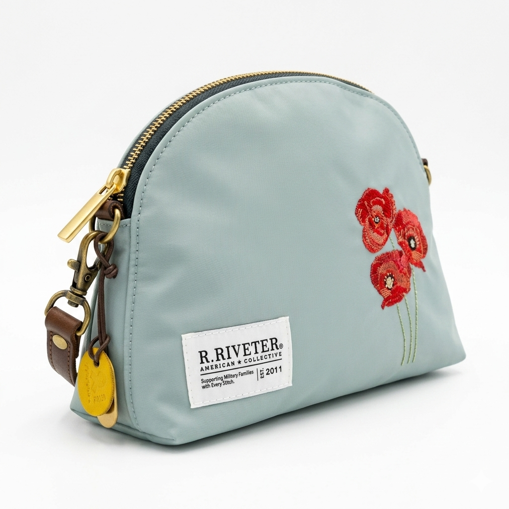 Light blue nylon zip pouch bag with gold zipper, red embroidered flowers, front logo patch