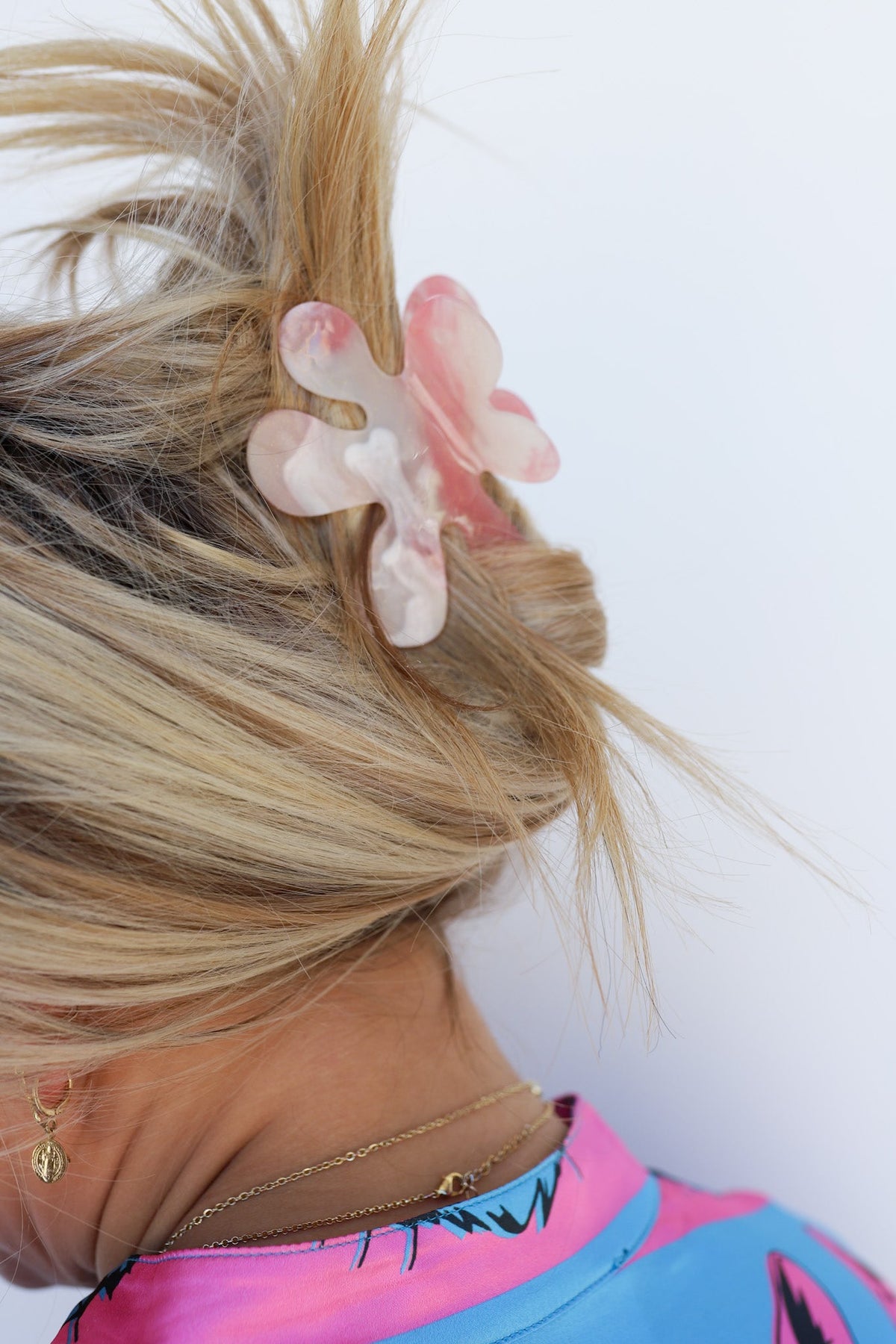 Color-changing hair claw with translucent white, pink and clear flower-shaped detail