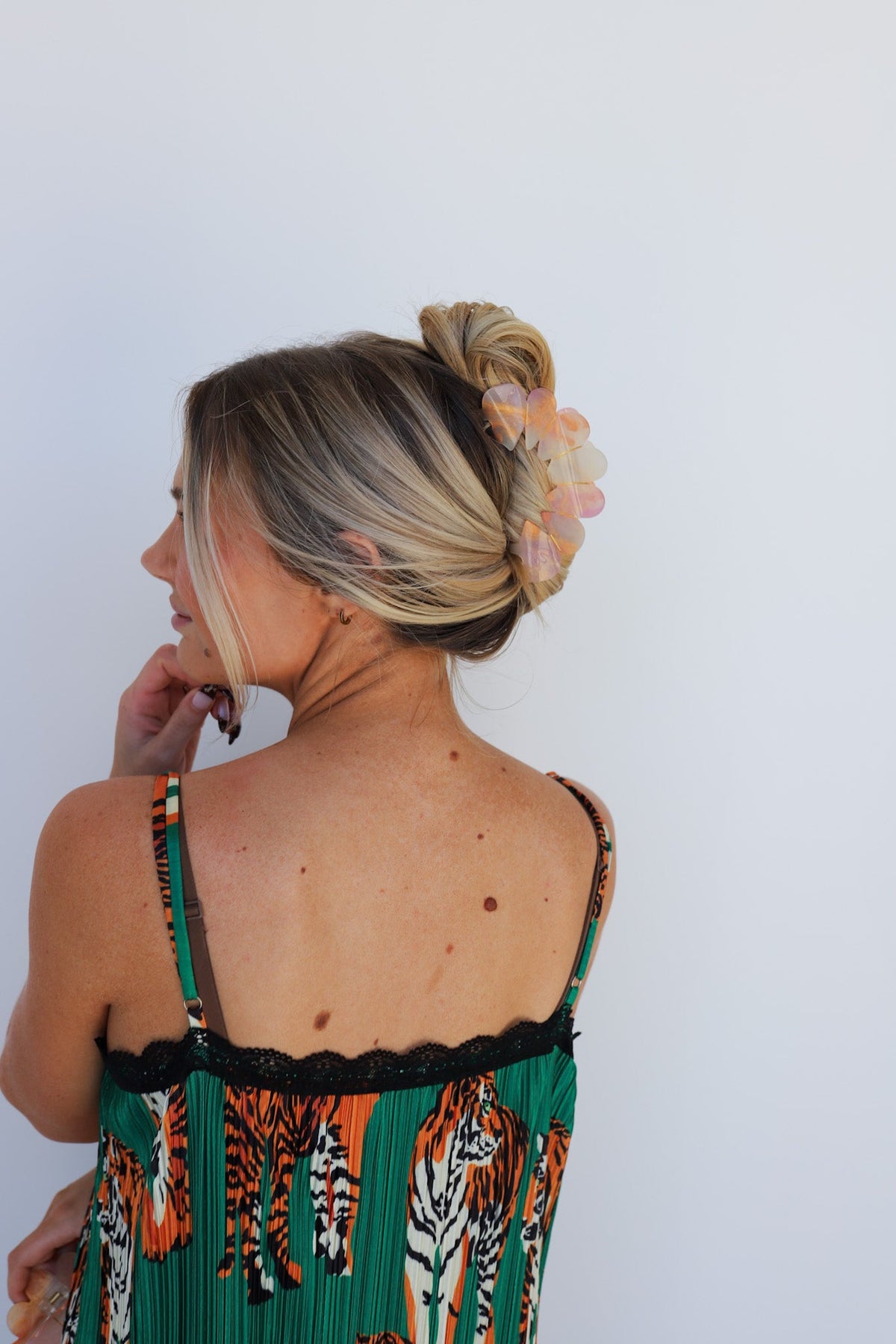 Heart flower hair claw clip in pink and peach tones on a blonde low bun