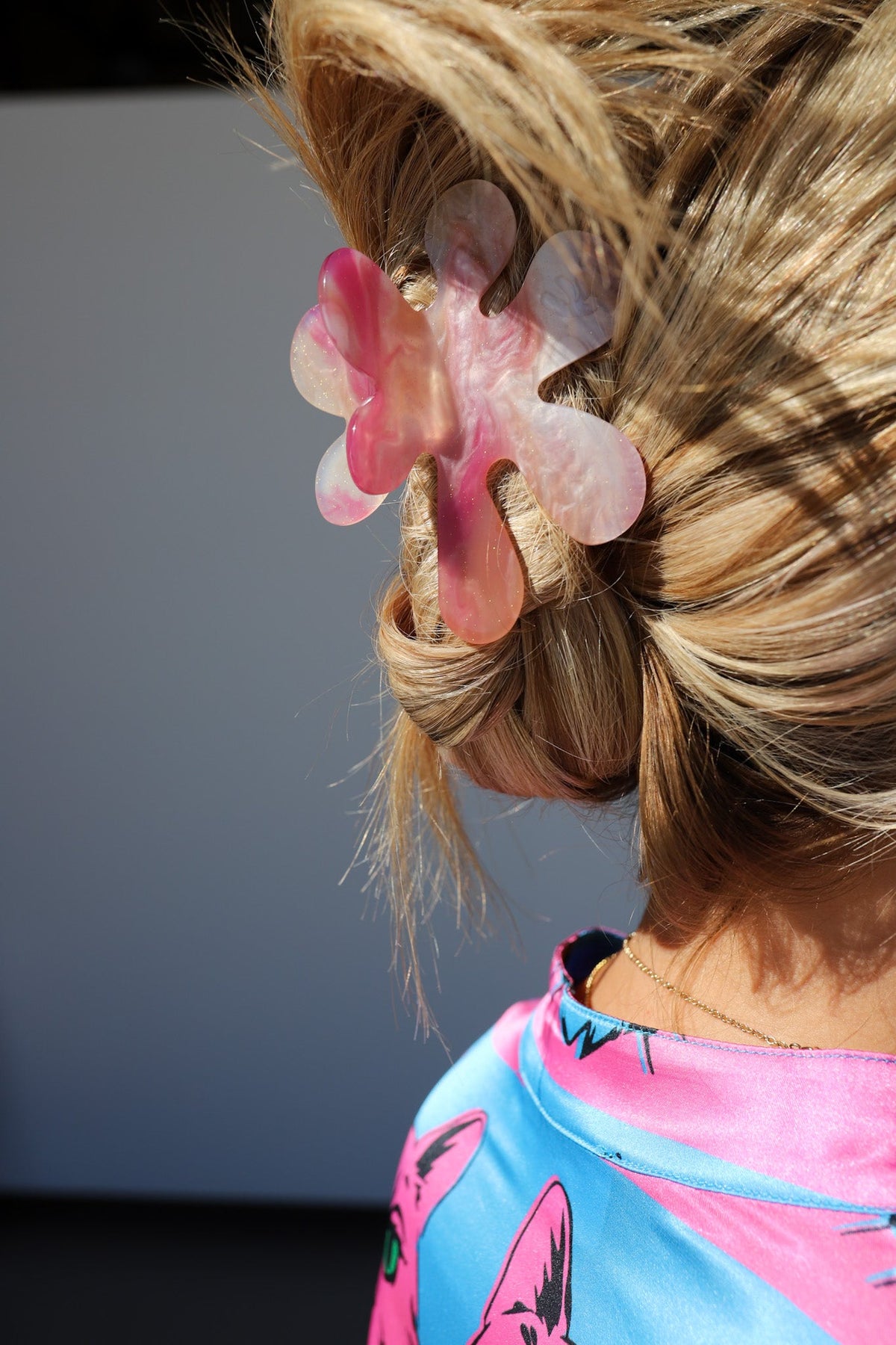 Translucent heart hair claw clip in pink and peach tones on blonde hair bun