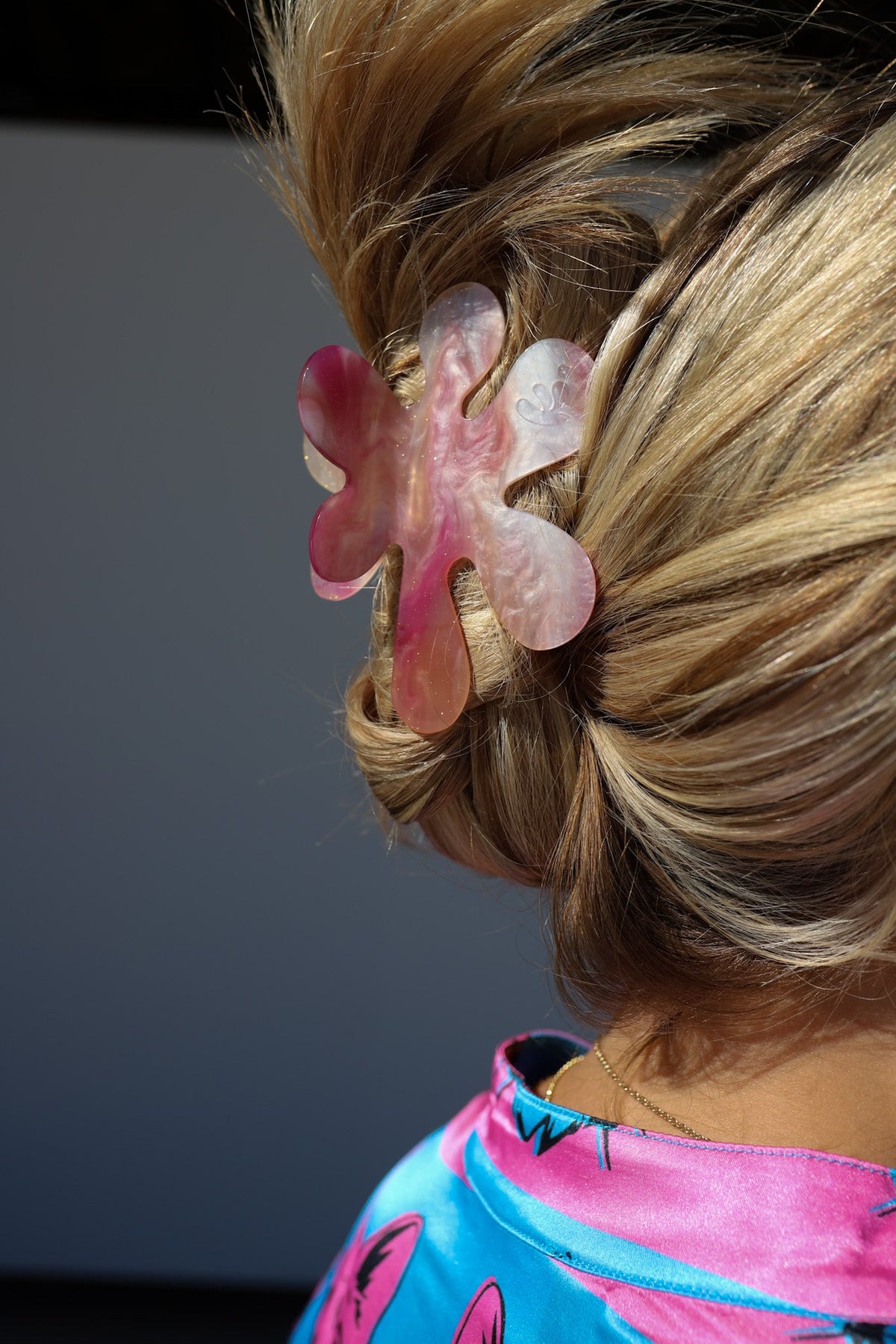 Heart-shaped hair claw clip with translucent pink and peach pieces on blonde hair