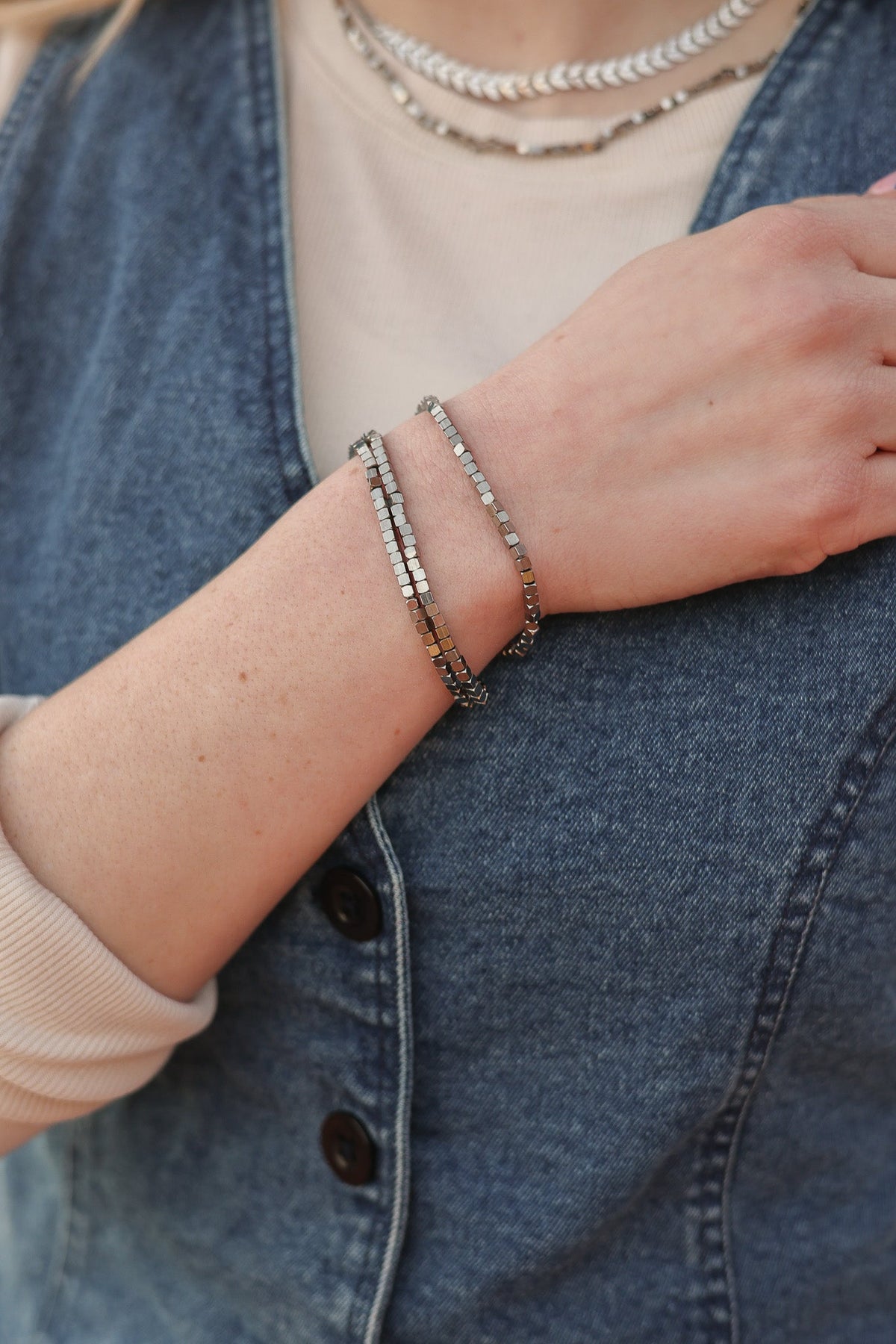 Silver-tone Ember bracelets with square beads worn in a stack