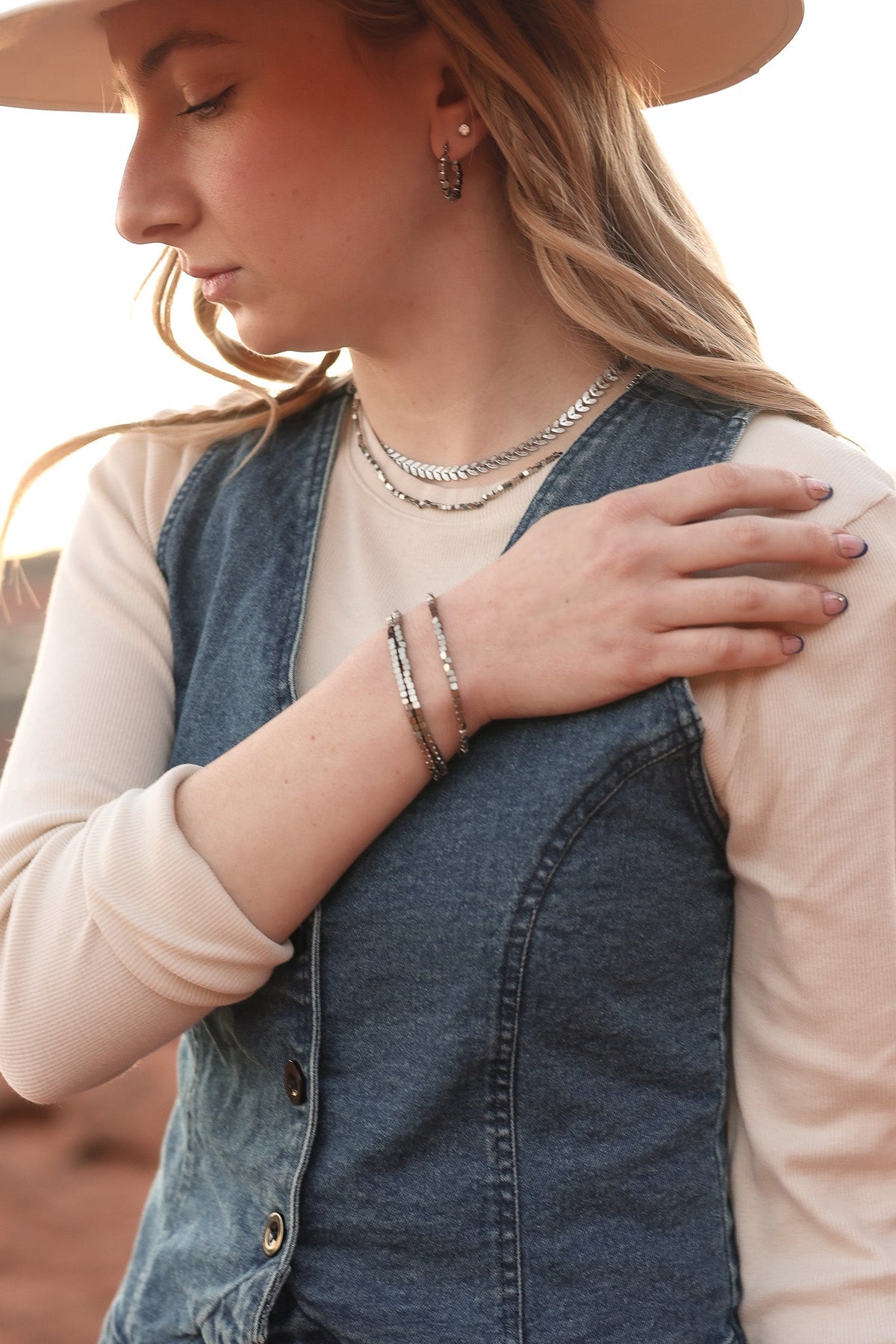 Stacked silver-tone Ember bracelets with small square beads on the wrist